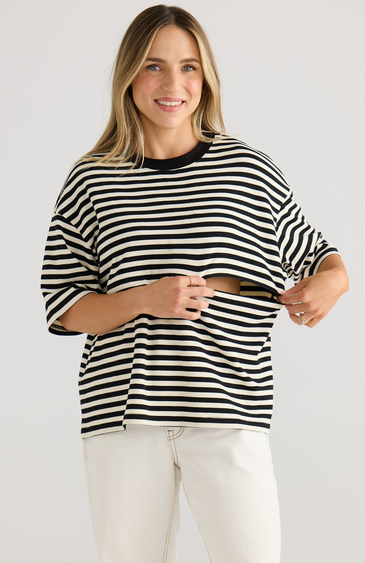 Woman wearing a black and white striped sweater on a plain background