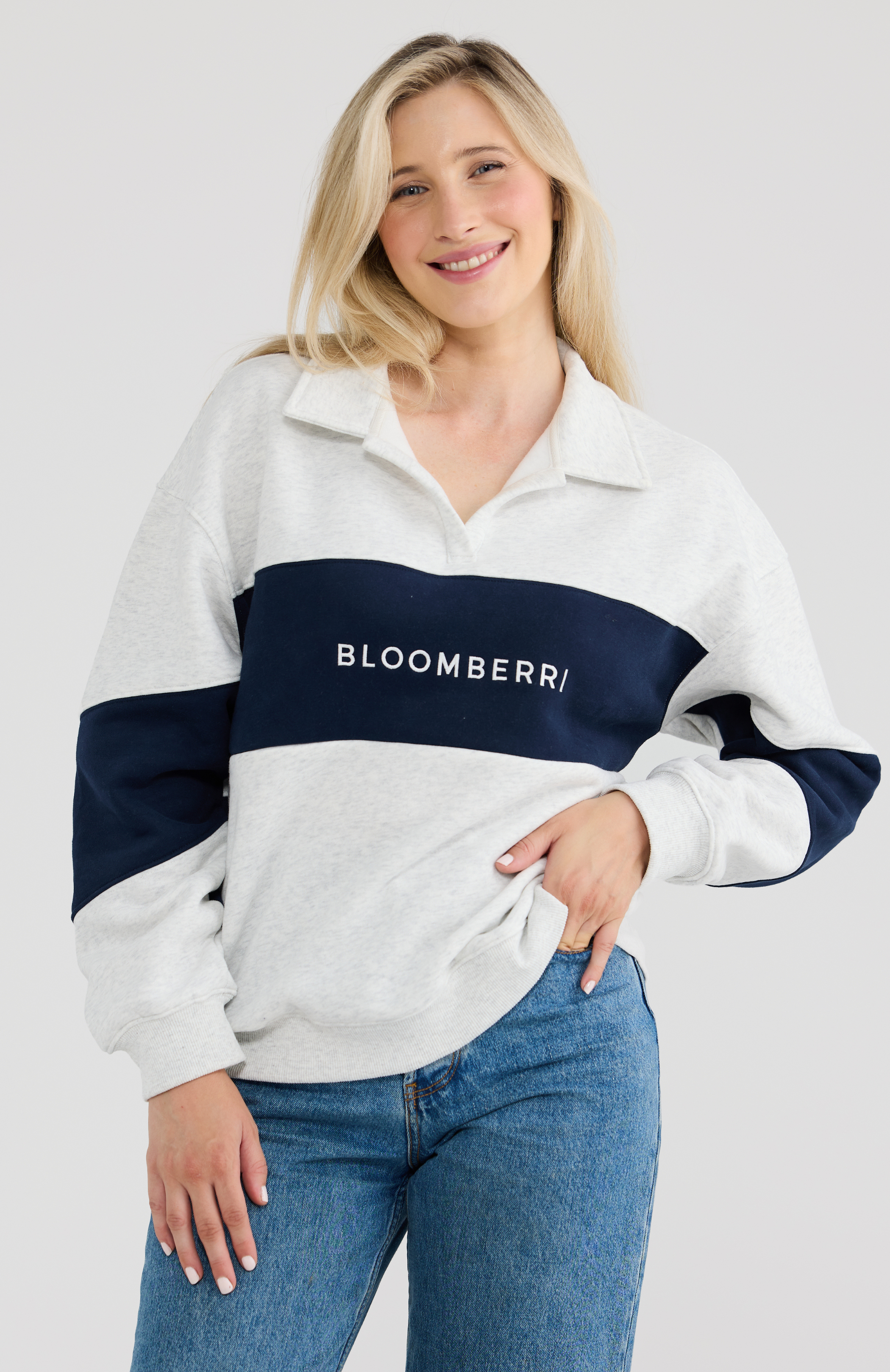 Woman wearing a grey and navy striped shirt with 'Bloomberri' logo on a light grey background
