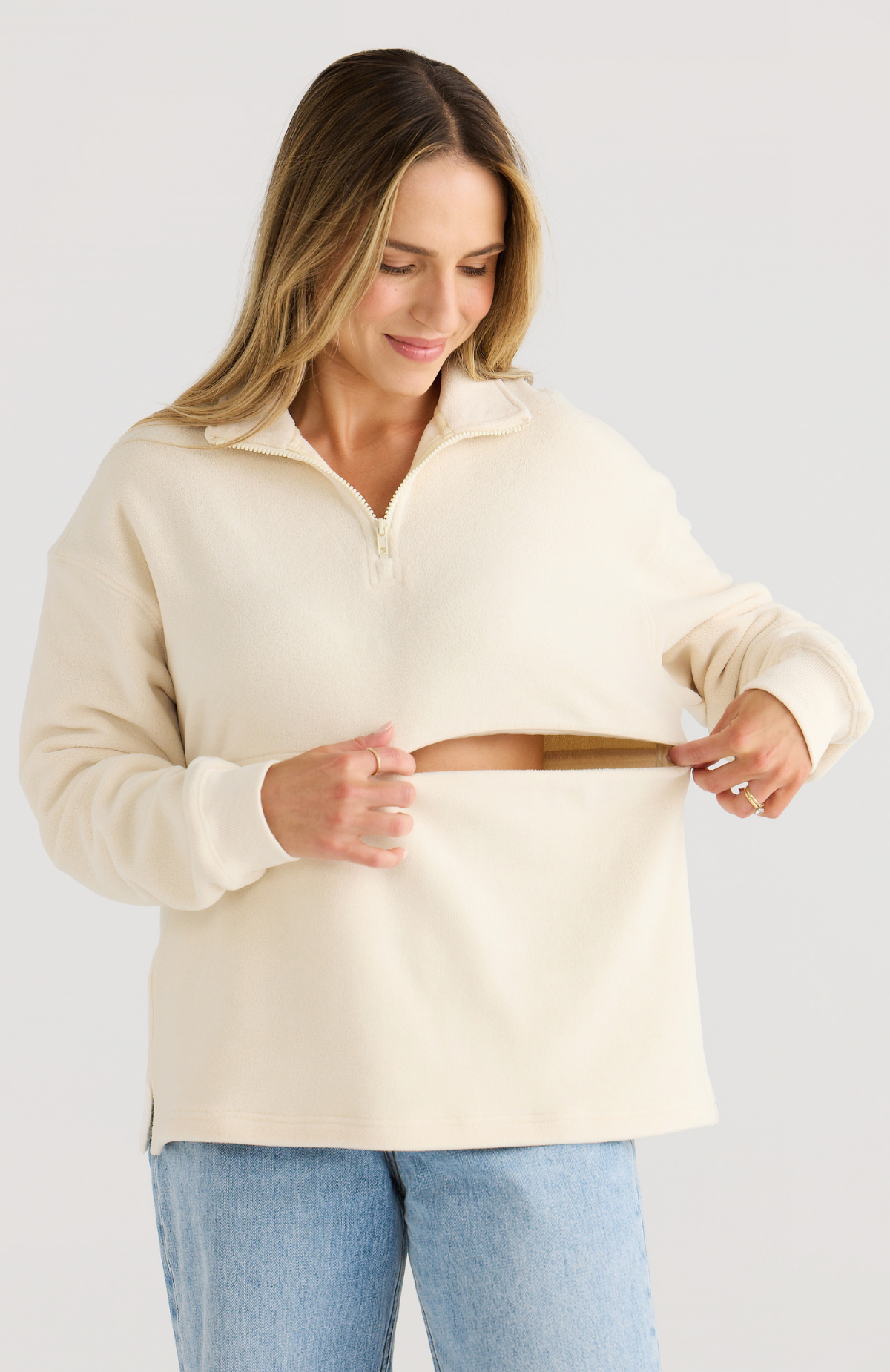 Woman wearing a cream-colored sweater against a light background