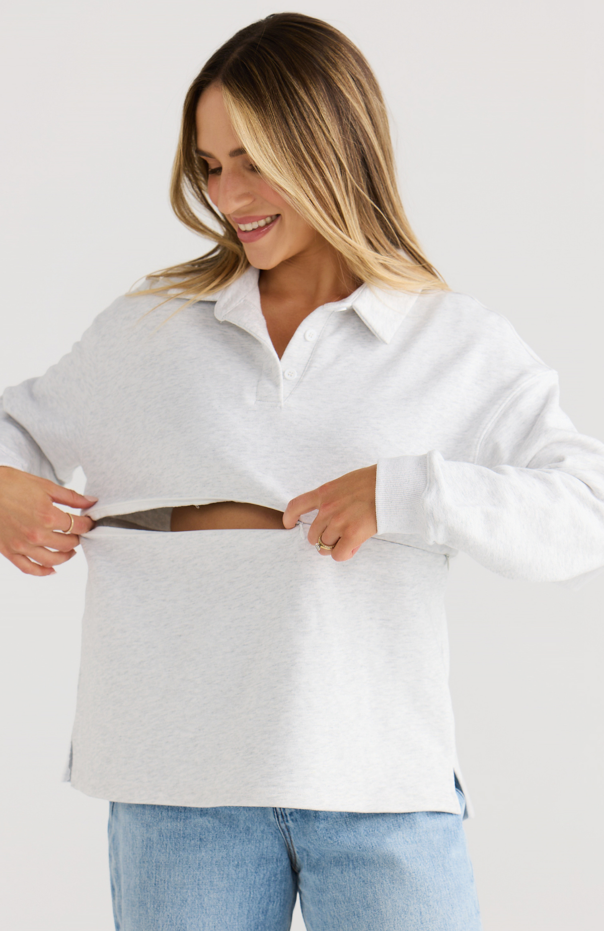 Woman wearing a grey oversized shirt on a white background