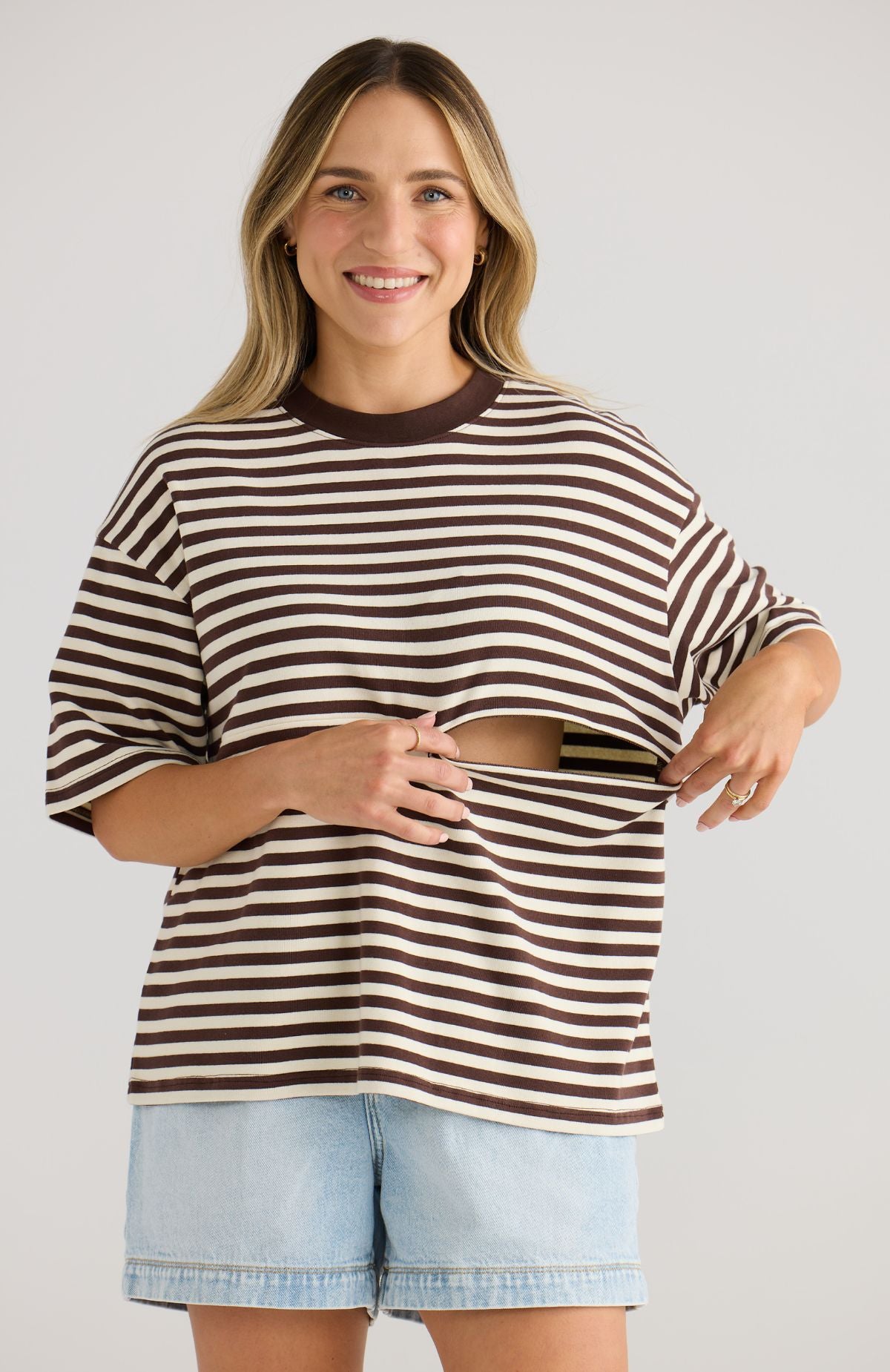 Woman wearing a brown and white striped top on a plain background
