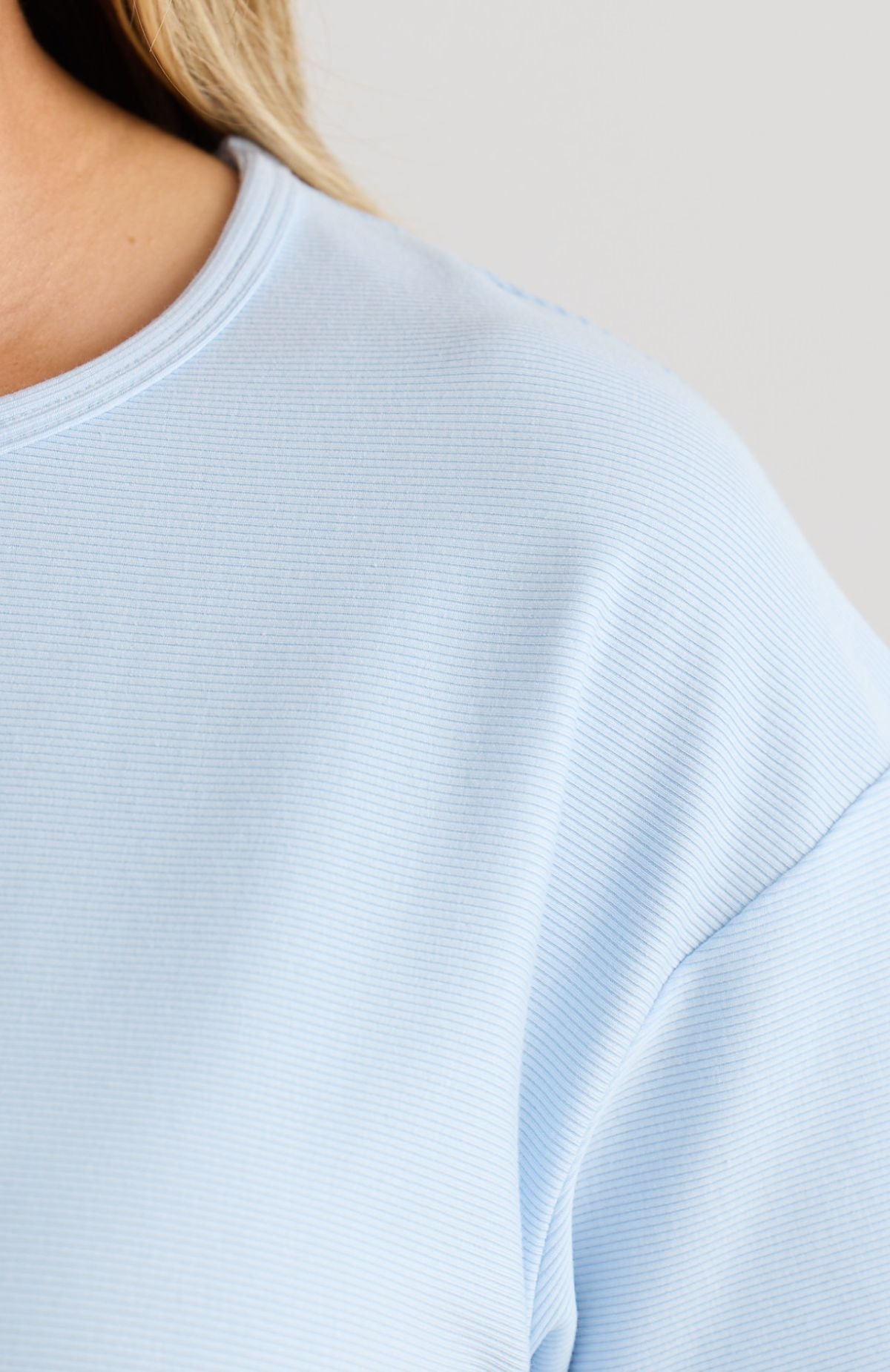 Light blue ribbed top worn by a person on a neutral background
