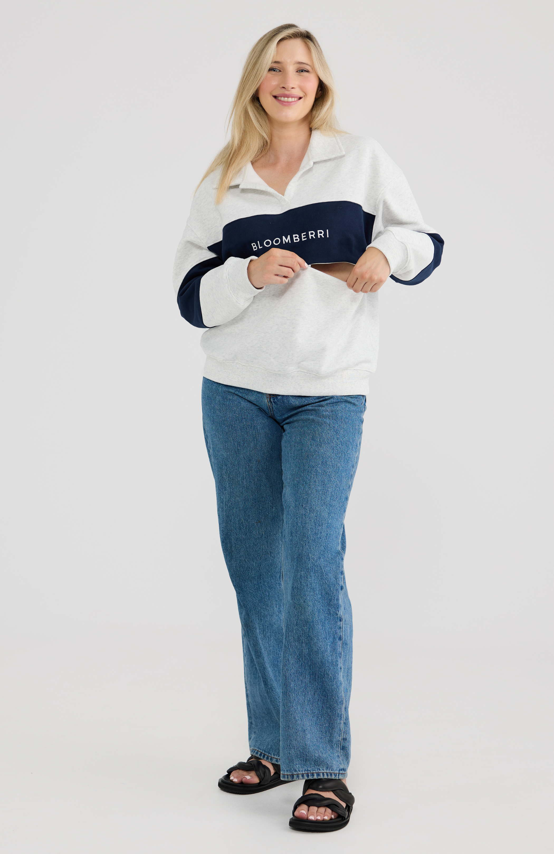 Woman wearing a grey and navy sweater with 'Bloomberri' branding.