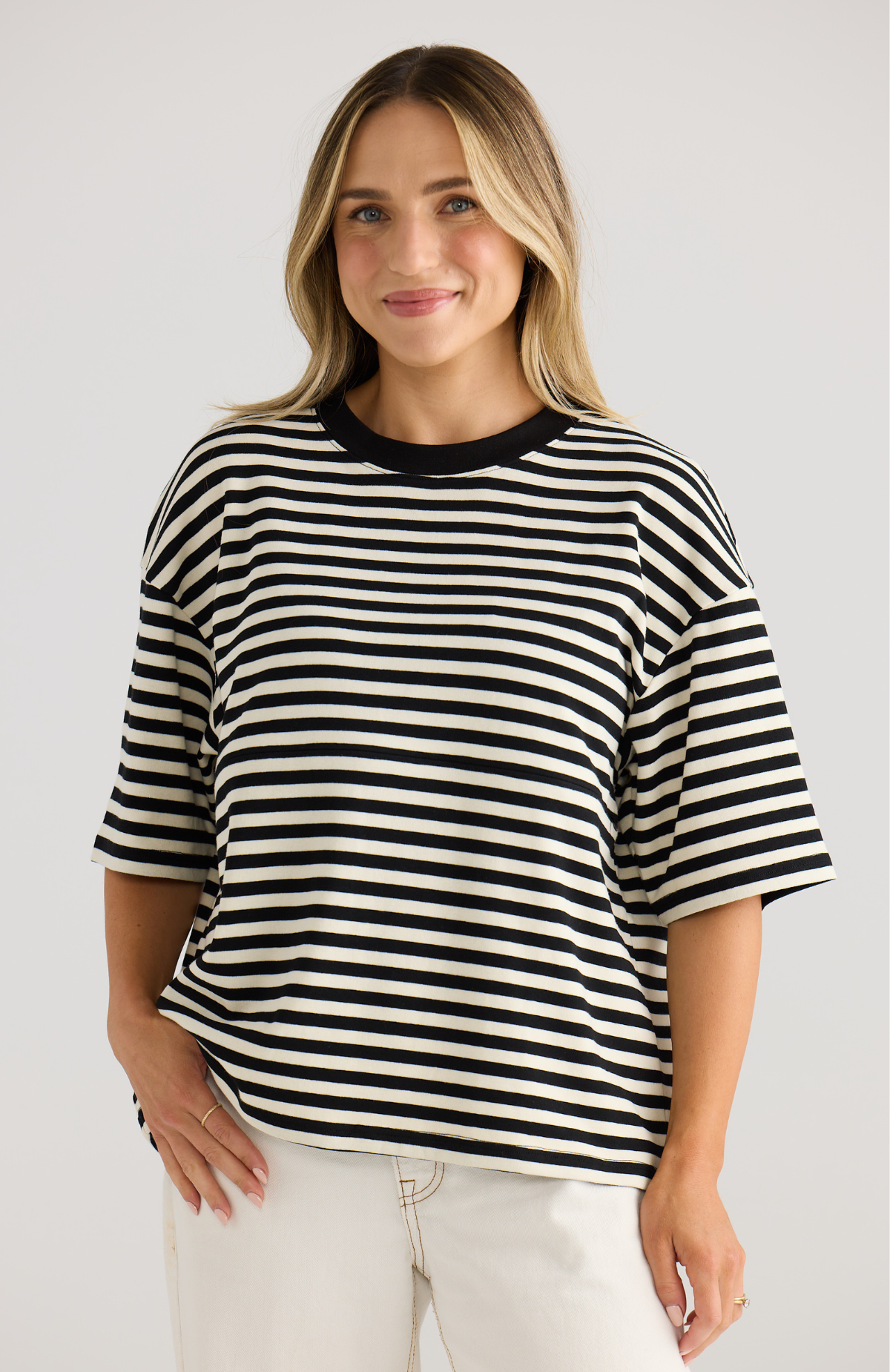 Woman wearing a black and white striped shirt against a plain background